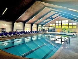 Una piscina techada, una piscina al aire libre de temporada, sombrillas
