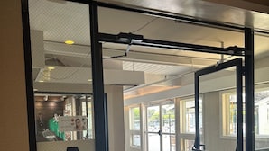 An ATM machine with a sign, an exit sign, and a view of the interior space. - Cape Cod Irish Village (Hyannis)