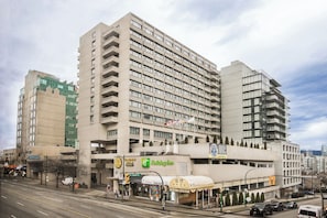 Ein mehrstöckiges Hotel mit moderner Fassade, einem Holiday Inn Schild und einem sichtbaren Parkplatz.