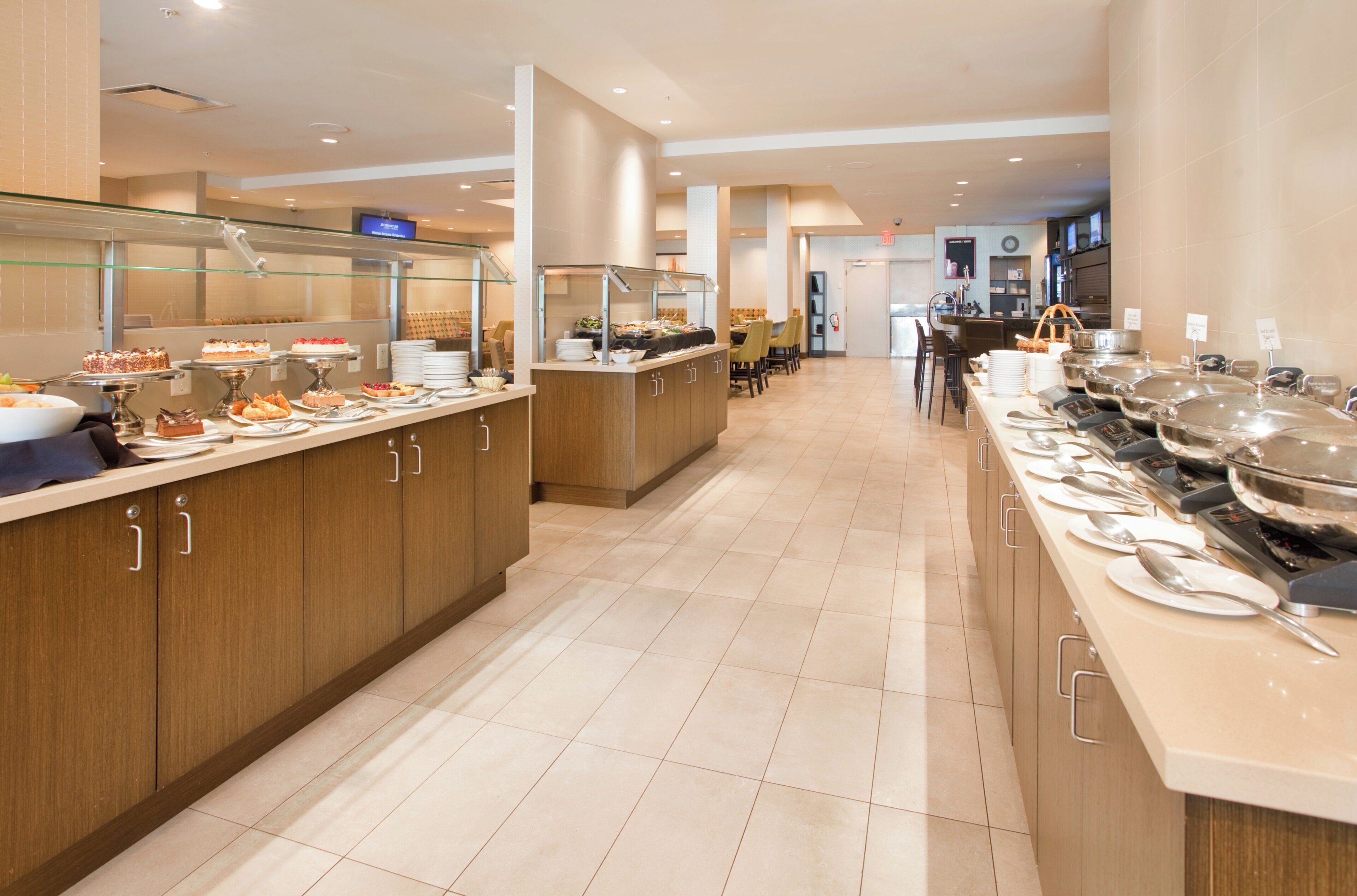 A buffet area with multiple serving stations, a seating area, and a visible exit sign.