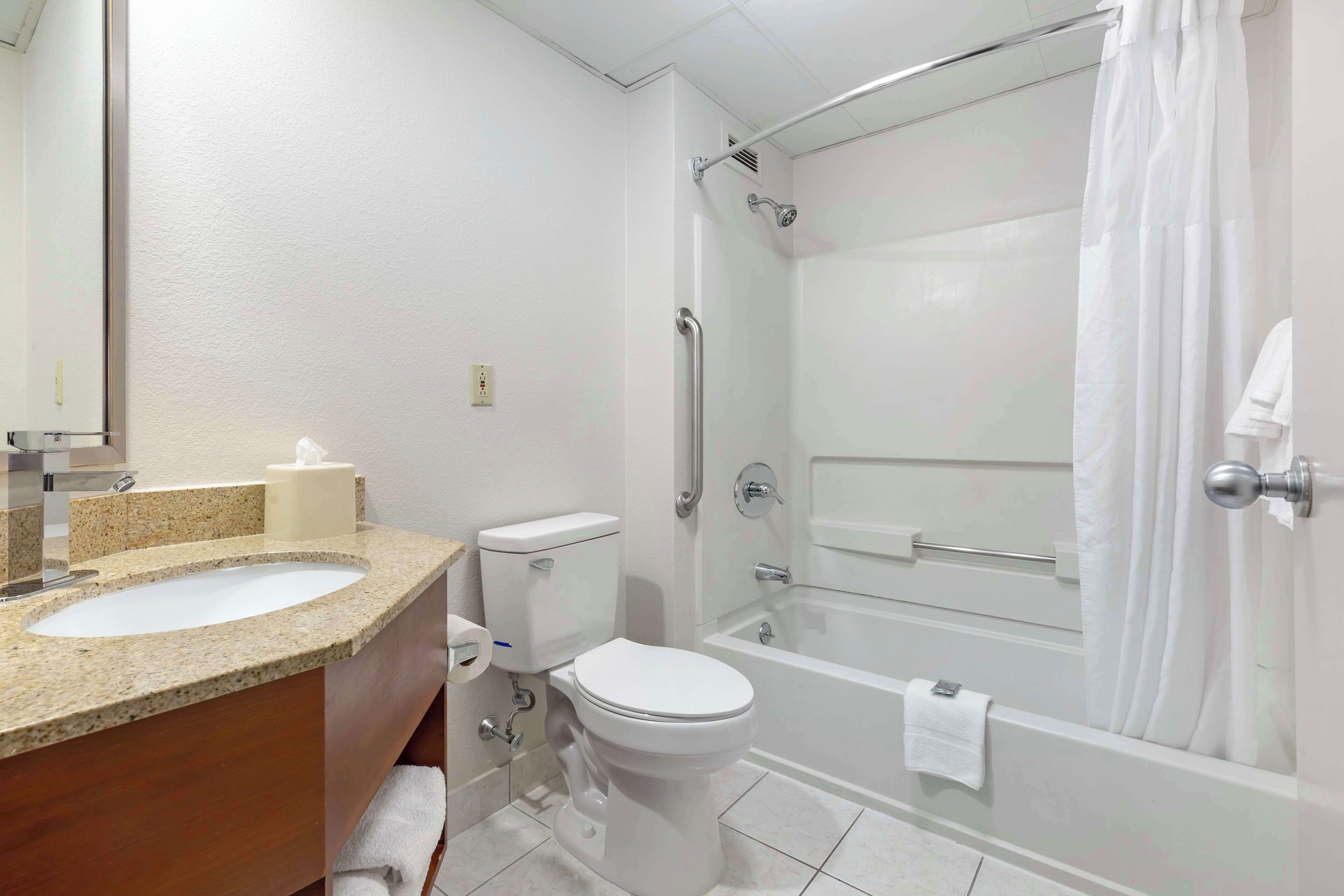 A bathroom with a sink, toilet, and bathtub.