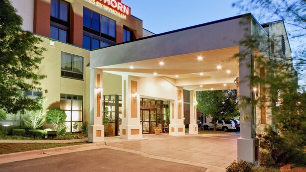 A hotel entrance with a covered walkway, large windows, and a sign reading "HAWTHORN SUITES BY WYNDHAM". - Hawthorn Suites by Wyndham Midwest City Tinker AFB (Midwest City)