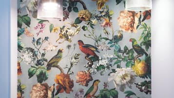 Una pared con papel tapiz floral que muestra aves y flores.