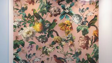 A room with a floral wallpaper and two pendant lights.