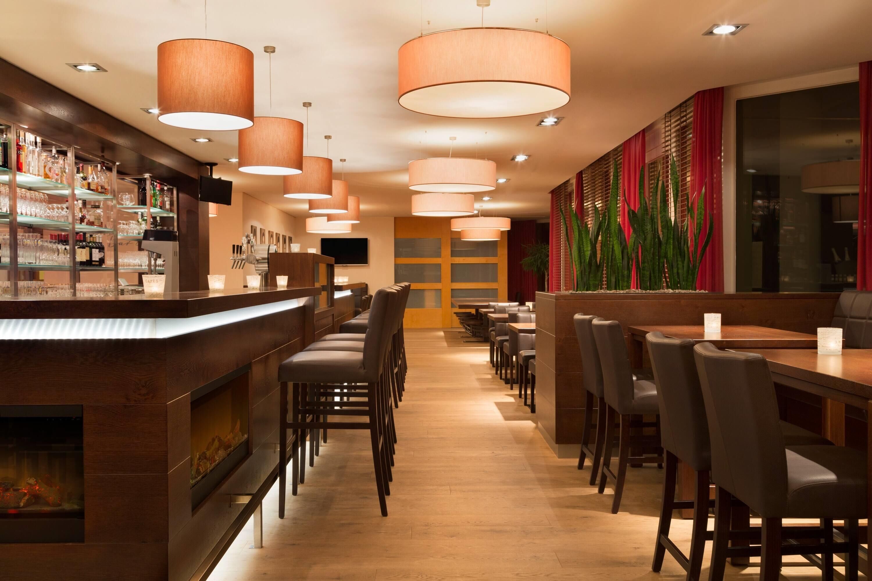 Un restaurante con barra, mesas y sillas de madera.