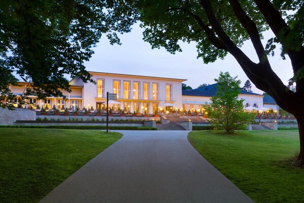 A building with a paved pathway leading to a set of stairs.