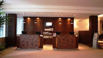 A reception area with two counters, a television screen, and a bulletin board.