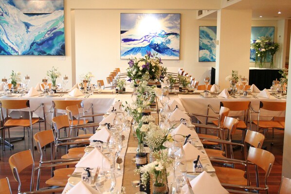 A banquet hall with long tables set for a formal event, featuring floral centerpieces and clear glassware. - Crowne Plaza Perth by IHG (East Perth)