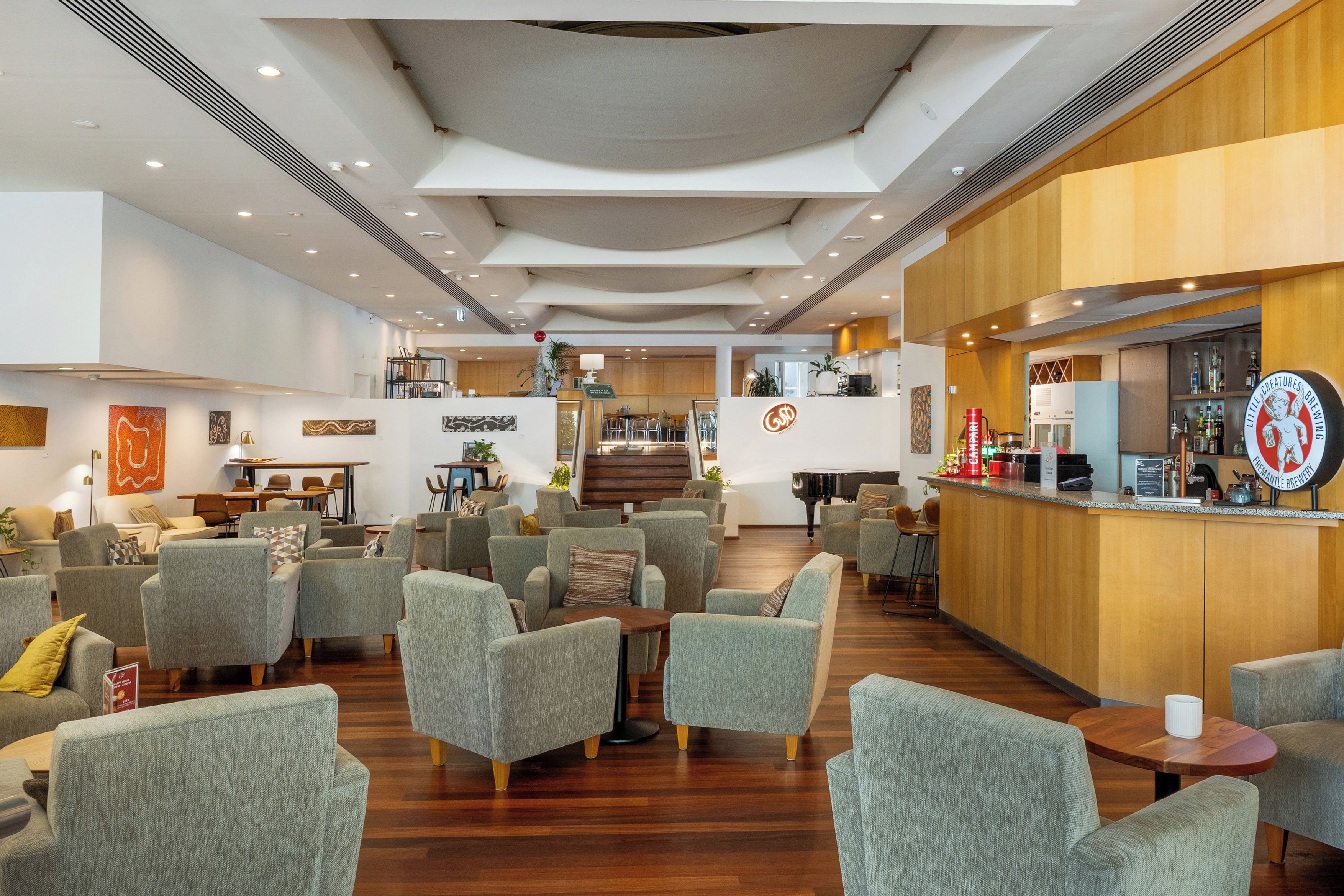Un hall d’entrée spacieux avec plusieurs coins salon, un bar et un piano.