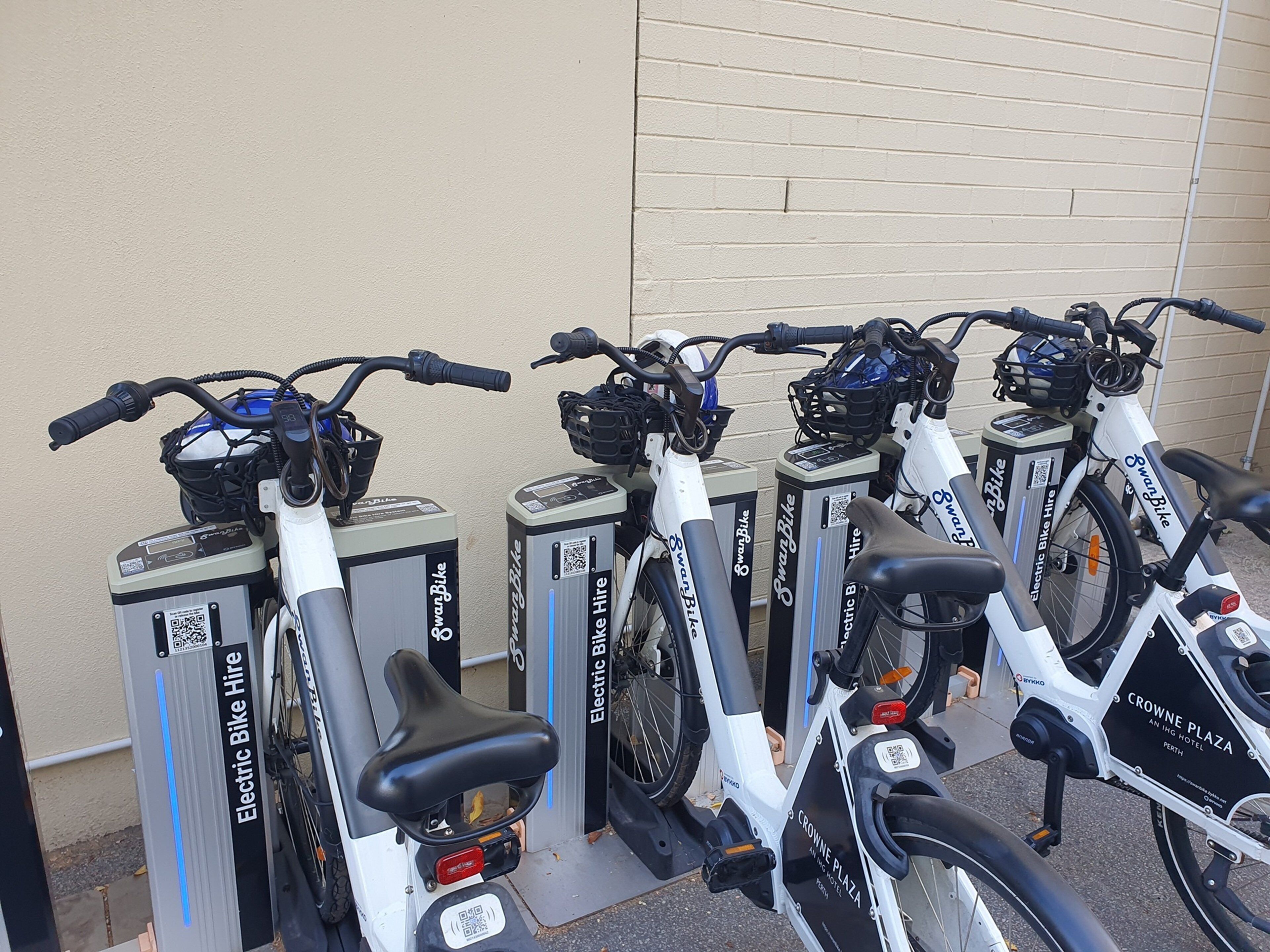 Una filera de bicicletes elèctriques aparcades a la paret.