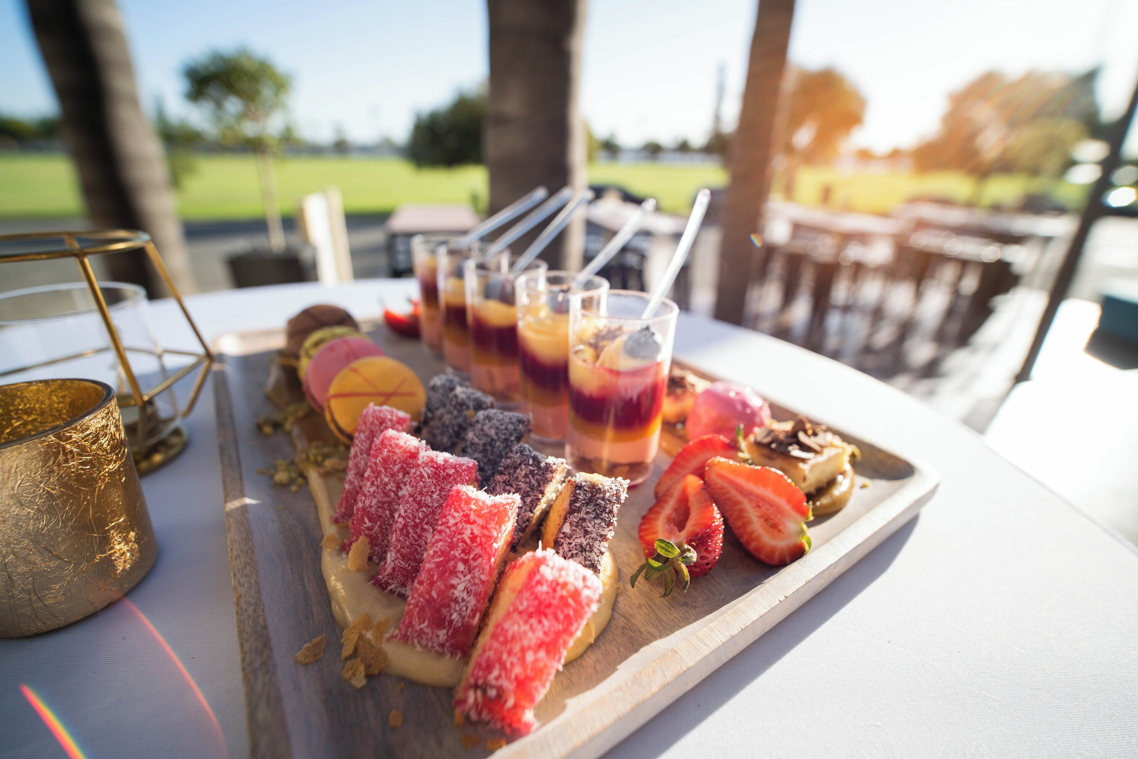 A tray of food and drinks on a table with a view of trees and sky.