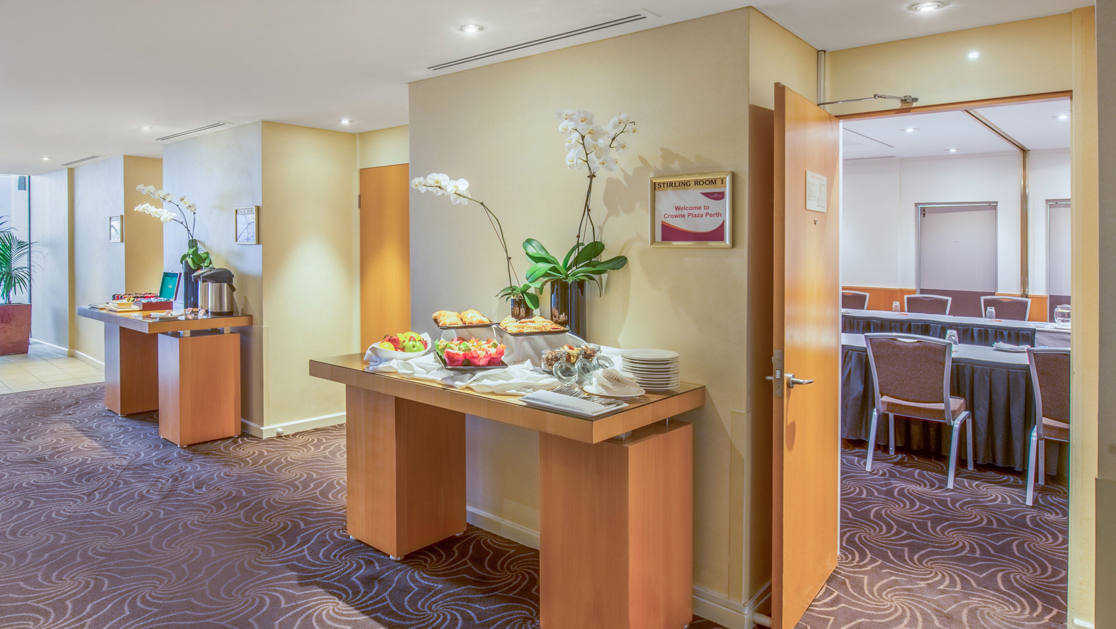 A hotel room with a reception desk, a dining area, and a conference room.