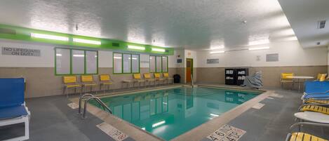 A swimming pool with multiple lanes, yellow chairs, and a lifeguard station.