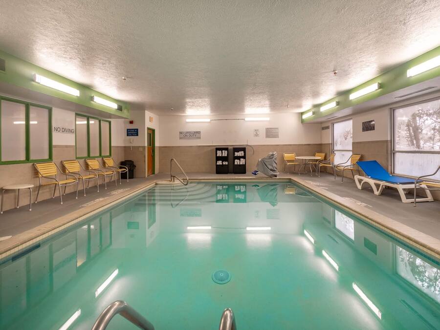 An indoor swimming pool with clear signage, including "NO DIVING" and "NO LIFEGUARD ON DUTY".