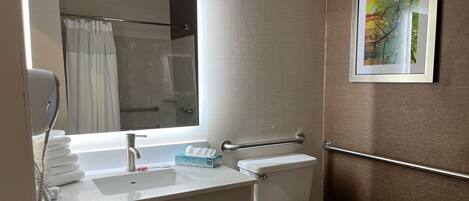 A bathroom with a sink, toilet, and a shower area.