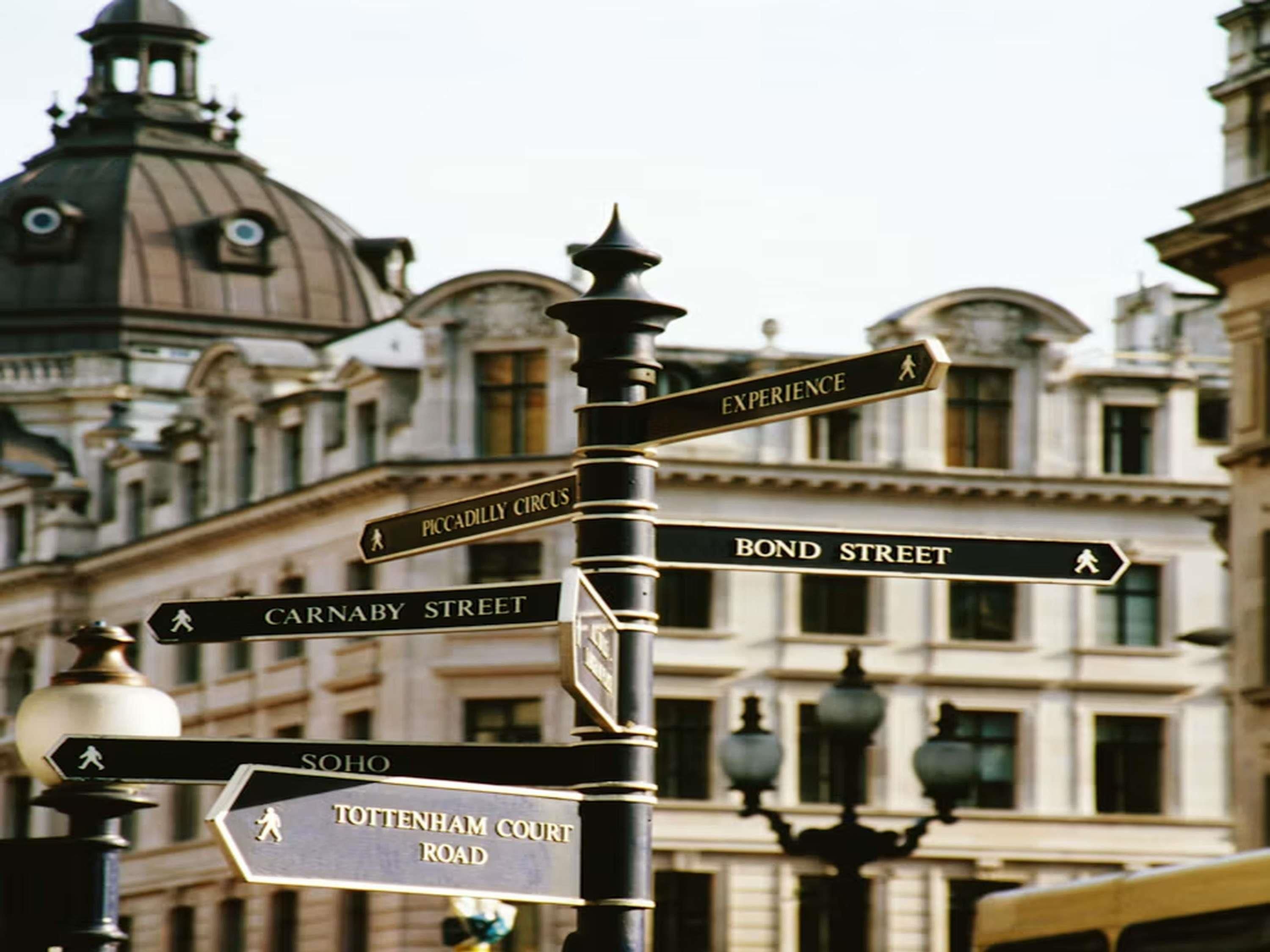 A street sign with directions to Piccadilly Circus, Bond Street, Carnaby Street, Soho, and Tottenham Court Road.