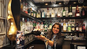 A bar area with a variety of liquor bottles and glasses.