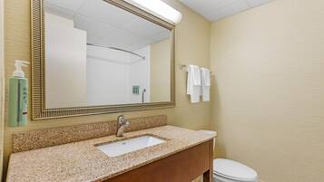A bathroom with a sink, mirror, and toilet.