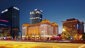 A hotel with traditional architecture, modern buildings in the background, and a well-lit entrance. - XI’AN DAJING CASTLE HOTEL (Xi'an)