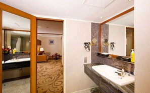 A hotel bathroom with a double sink, a large mirror, a hairdryer, and a towel dispenser. - XI’AN DAJING CASTLE HOTEL (Xi'an)