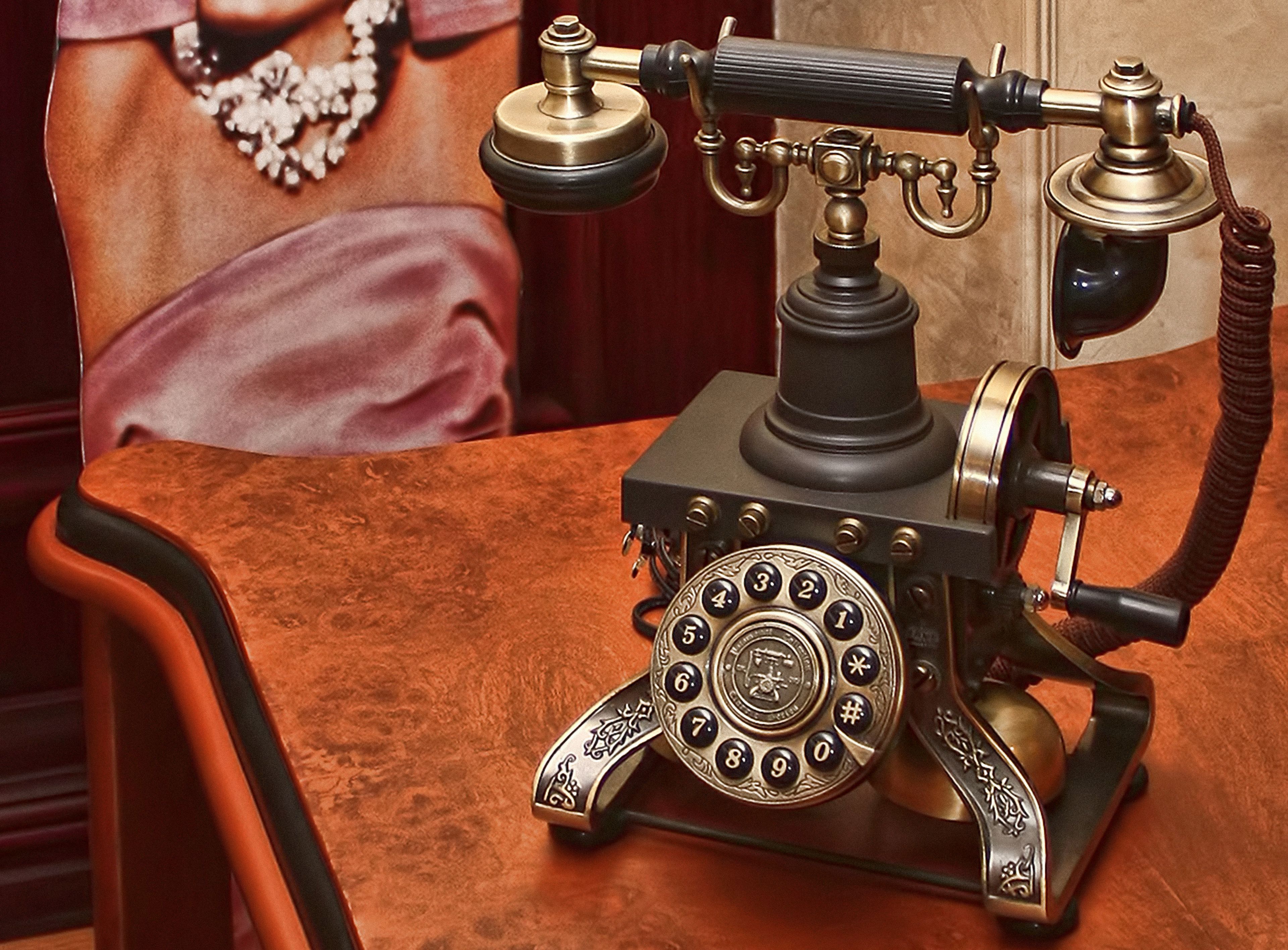 Un vieux téléphone à cadran rotatif posé sur une table en bois.
