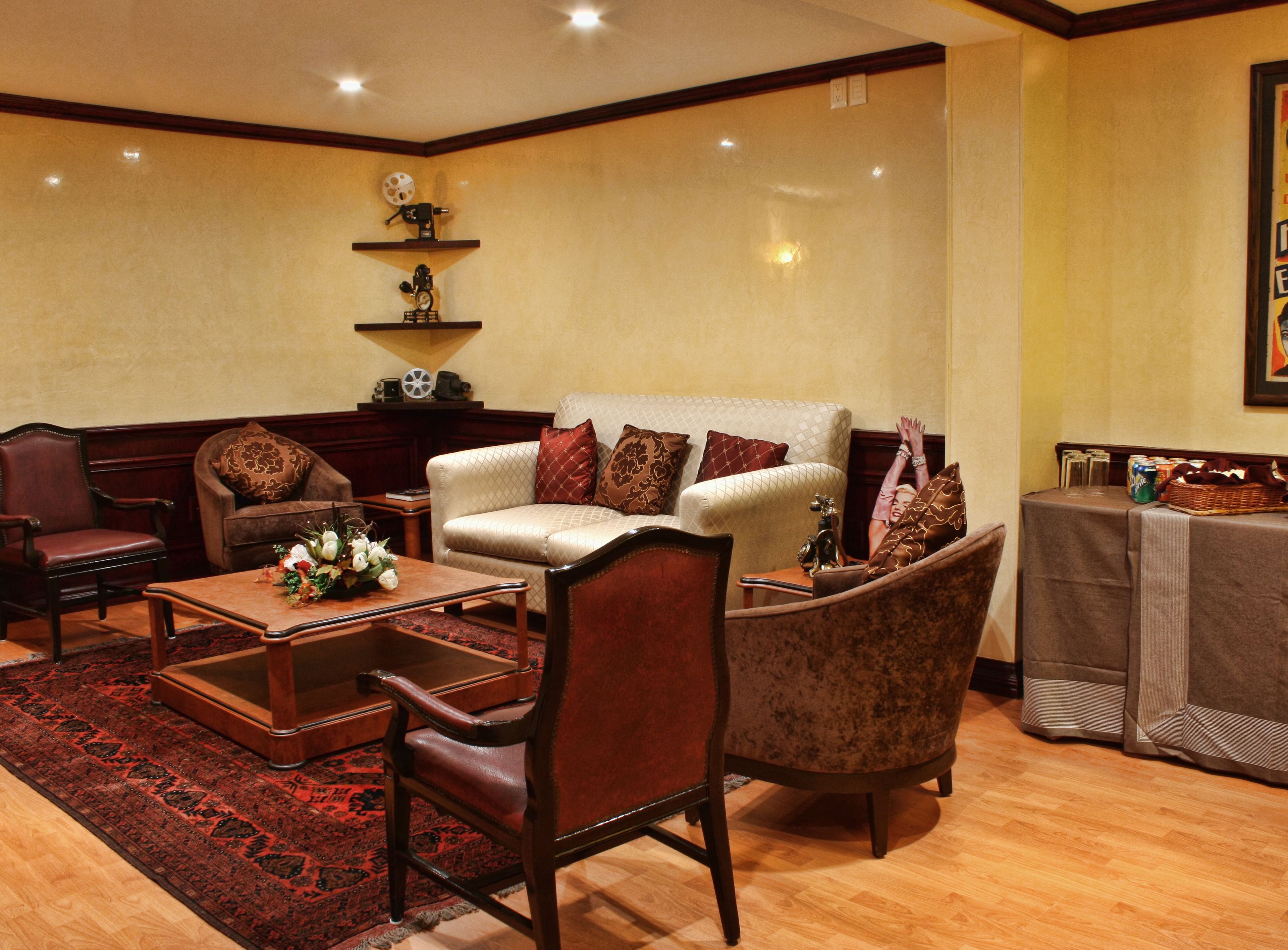 Un salon traditionnel avec un canapé, des fauteuils, une table basse et une cheminée.