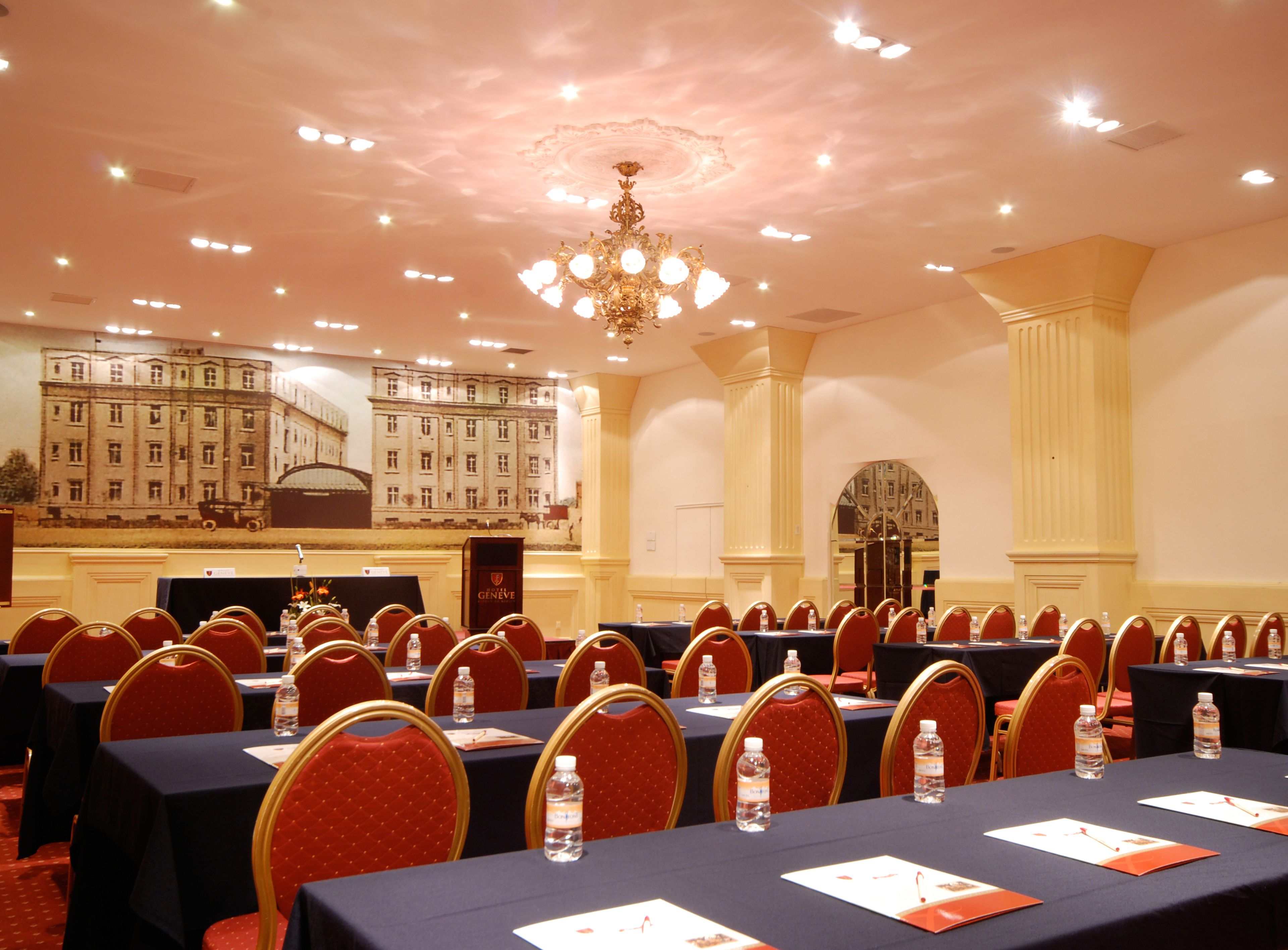A conference room with tables, chairs, and a chandelier.
