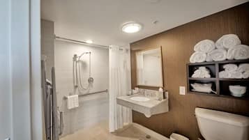 A modern bathroom with a shower, toilet, and sink.