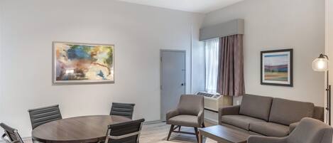 Una sala de estar moderna con una mesa redonda, sillas de cuero, un sofá y una mesita de centro.