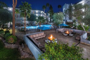 An outdoor pool area with lounge chairs and a fire pit. - Holiday Inn & Suites Phoenix Airport North by IHG (Phoenix)