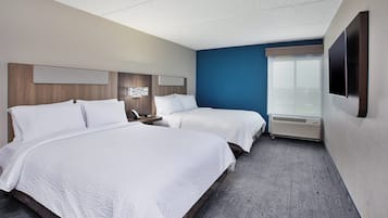 Une chambre d’hôtel avec deux lits, une grande fenêtre, un téléviseur à écran plat et un système de climatisation intégré.