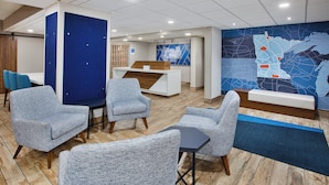 A modern lobby with seating areas, a reception desk, and a large wall map.