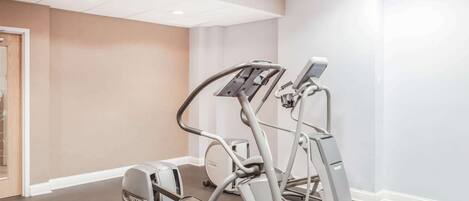 Un gimnasio con cintas de correr y una máquina elíptica.