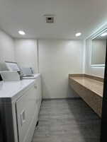 A laundry area with a washing machine, dryer, and a countertop with a sink.