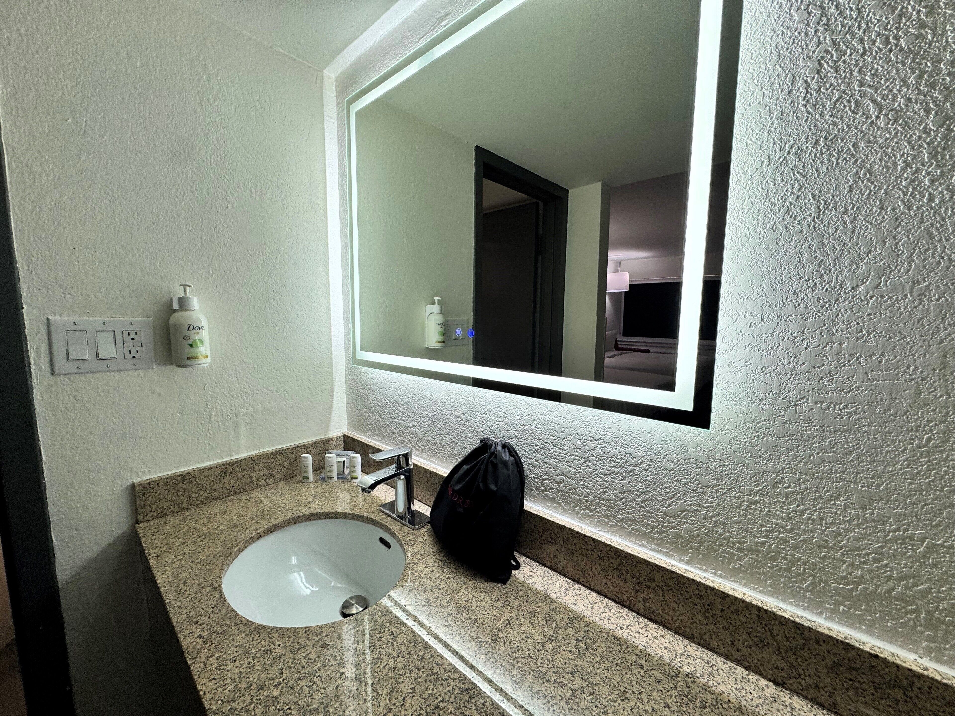 Une salle de bain équipée d’un lavabo, d’un miroir et d’articles de toilette.