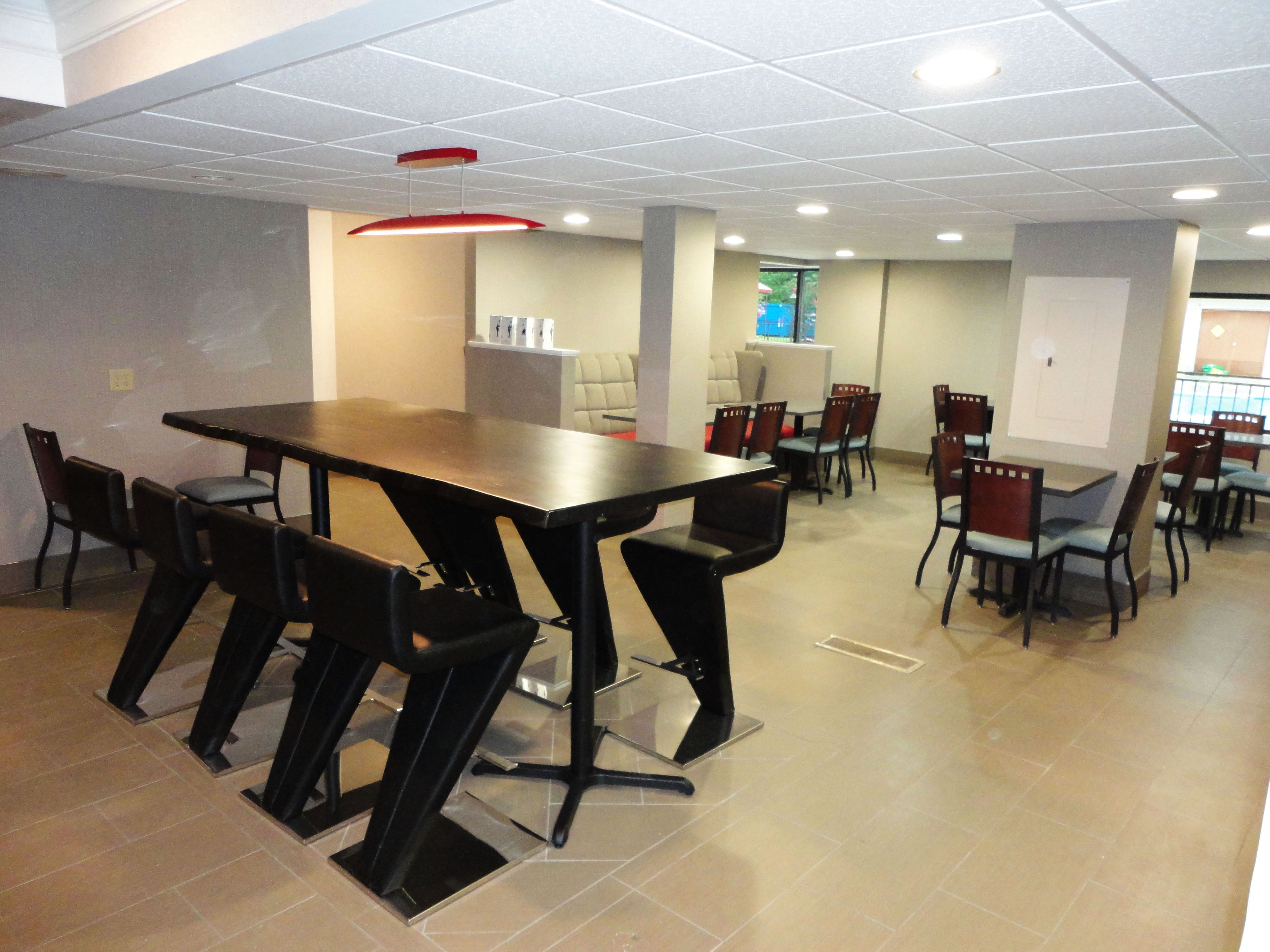 A conference room with a large table and chairs, white walls, and a ceiling with recessed lighting.