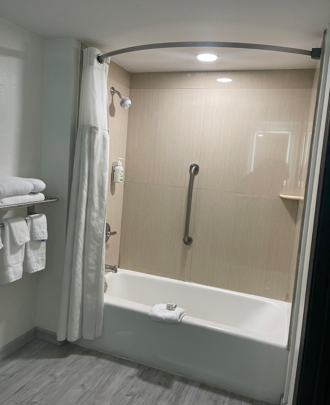 Un baño moderno con cabina de ducha, bañera y un perchero con toallas dobladas.