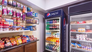A vending machine stocked with snacks and beverages, including chips, cookies, and sodas.