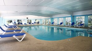 Una piscina cubierta, tumbonas