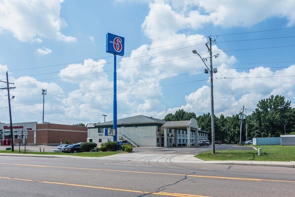 Ein Motel mit auffälligem, blauen Schild, einem Parkplatz und einem Walgreens-Markt im Hintergrund.