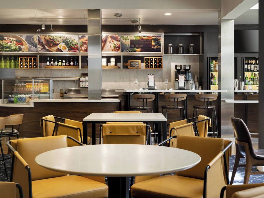 A modern restaurant with a bar area, seating arrangements, and a menu display.