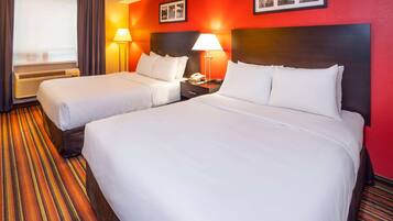 Ein Hotelzimmer mit zwei Betten, einer roten Wand und einem Streifenmuster-Teppich.