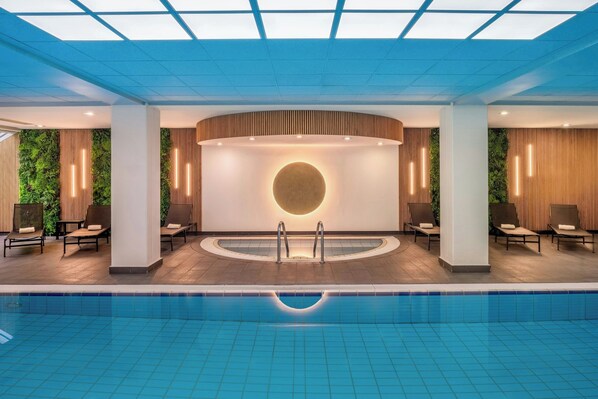 Relax by the pool surrounded by lounge chairs and lush greenery.