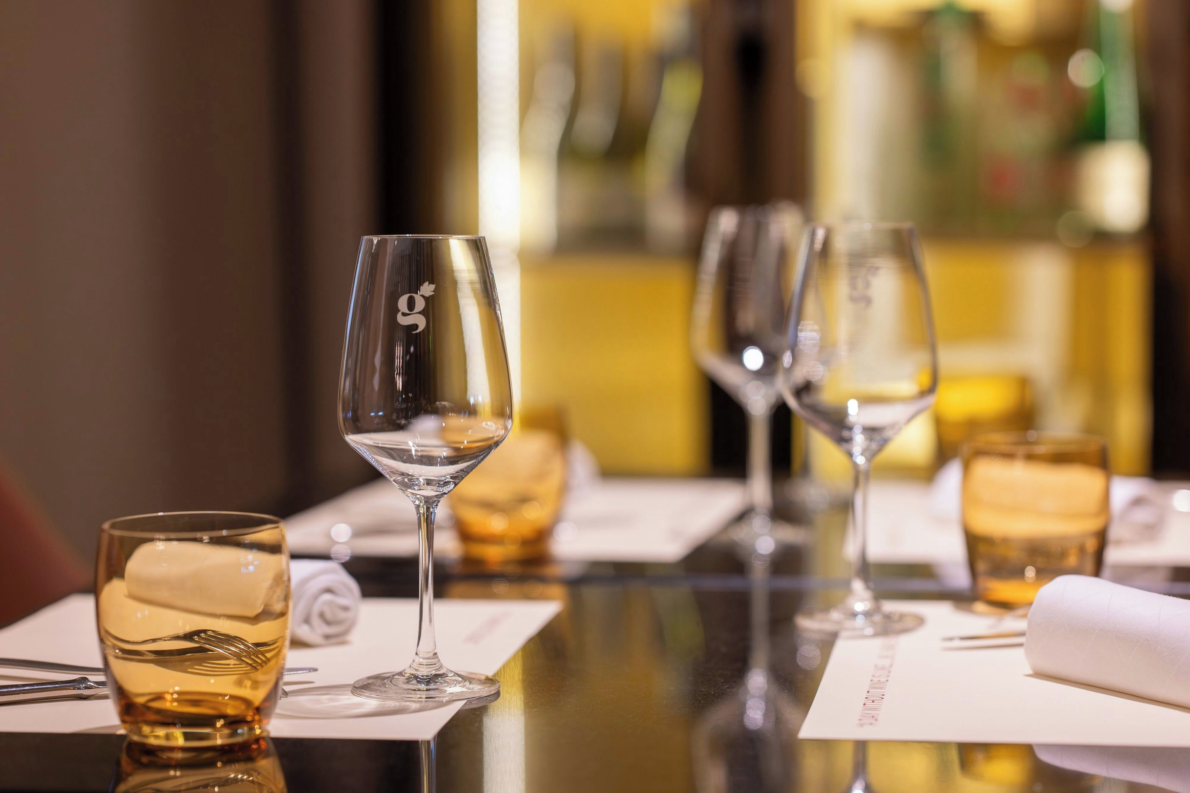 Una mesa de comedor con varias copas de vino y una botella.