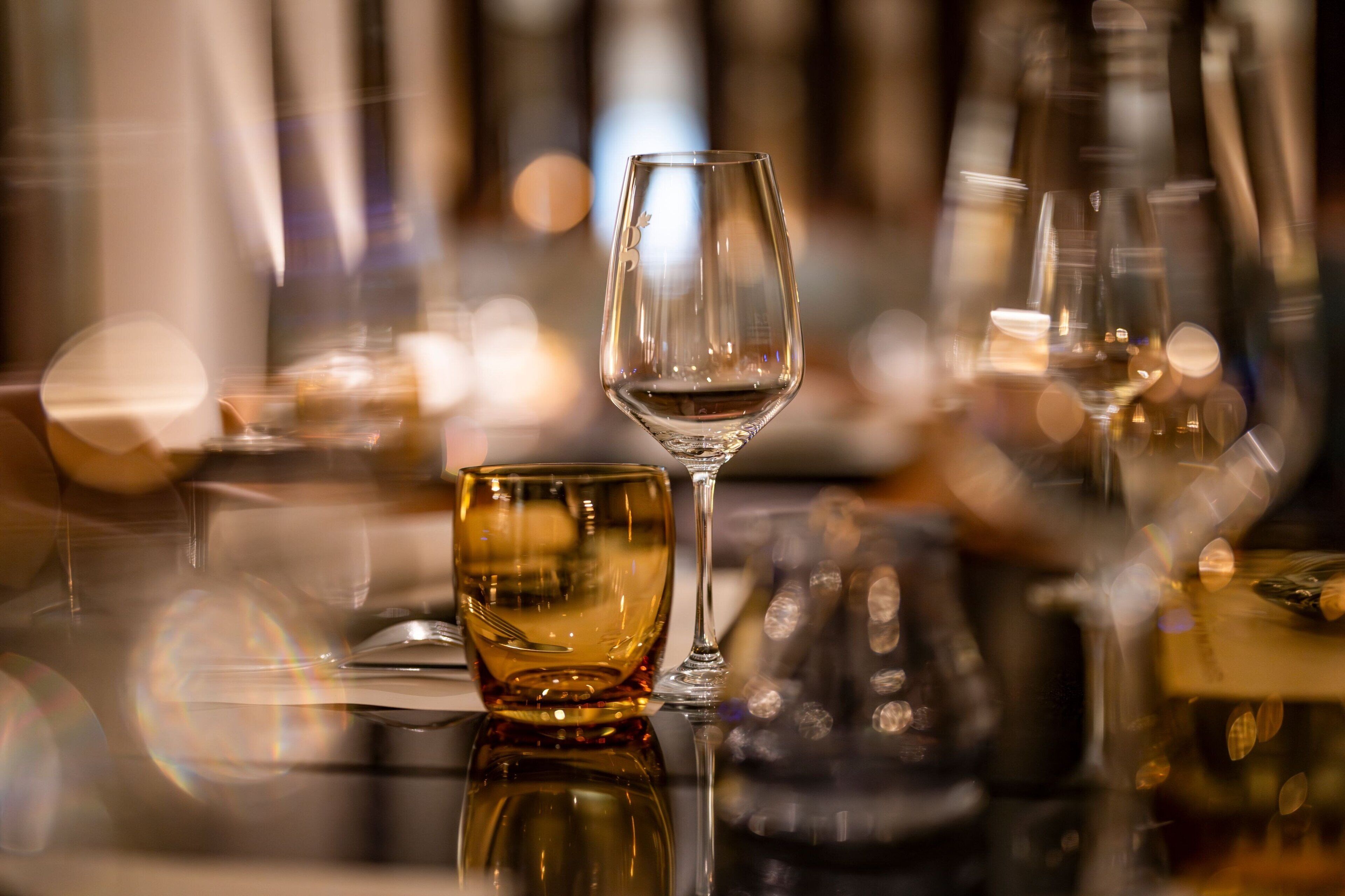 A bar setting with a glass of wine and a glass of whiskey.