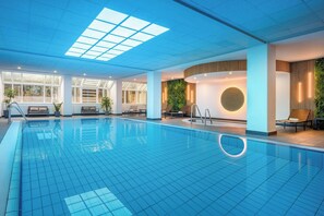 Relax by the pool, surrounded by lounge chairs and a cozy seating area.