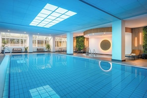 Relax by the pool, surrounded by lounge chairs and a cozy seating area.
