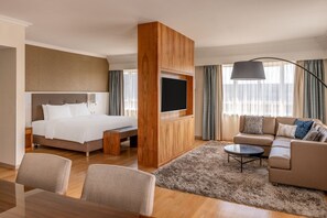 Relax in a spacious room with a large bed, flat-screen TV, and comfortable sofa.