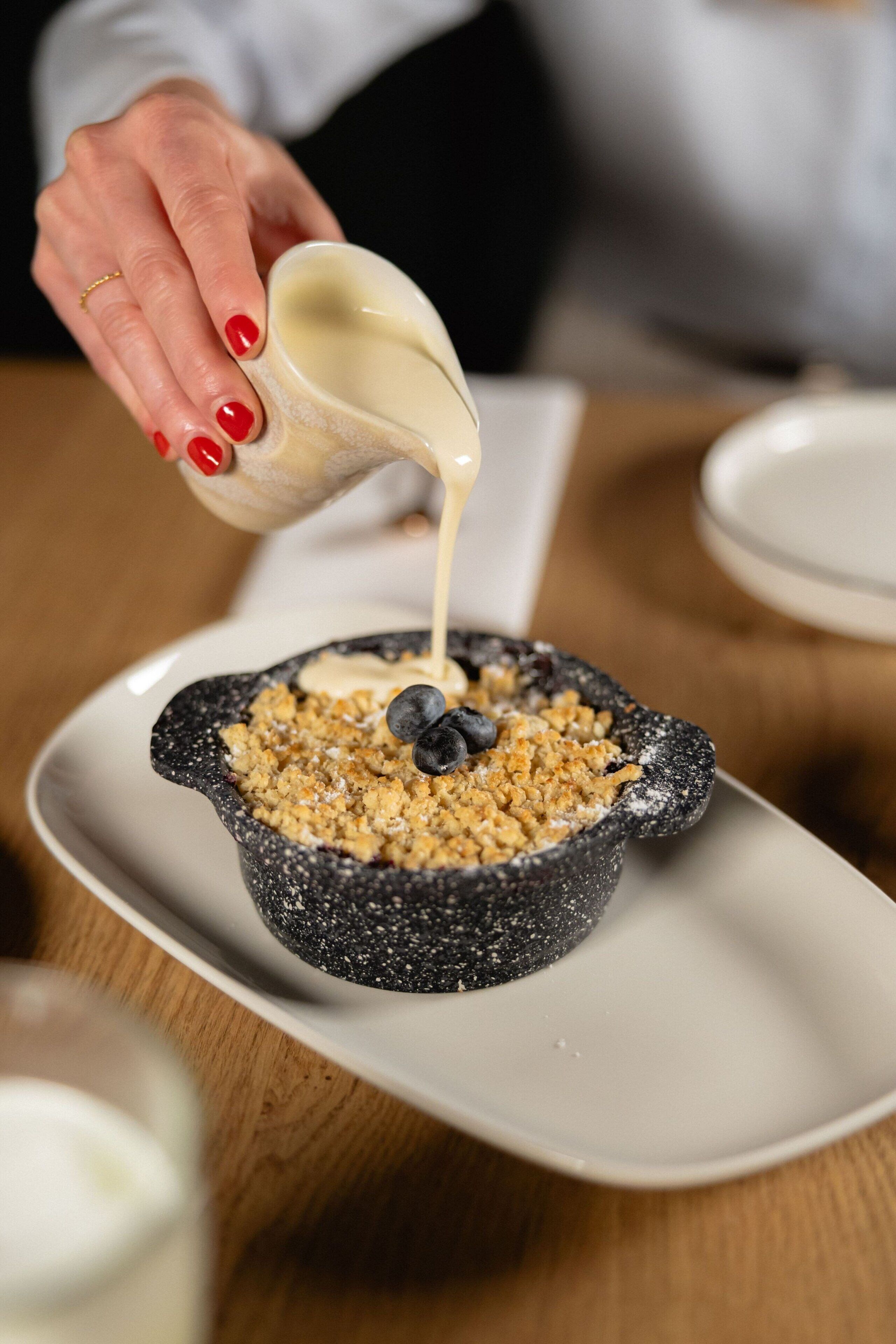 Ein Dessert in einer schwarzen Schale auf einem weißen Teller.