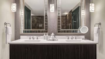 Une salle de bain moderne avec un meuble-lavabo à deux vasques, deux miroirs fixés au mur et une douche visible au fond.
